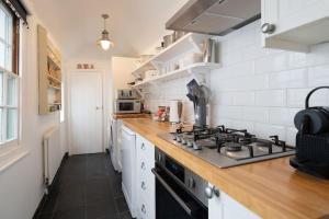 a kitchen with a stove and a counter top at Fisherman's Cottage, Whitstable in Whitstable
