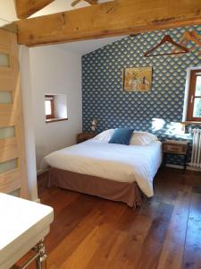 1 dormitorio con cama y pared azul en Là-Haut "Maison d'hôtes", en Antraigues