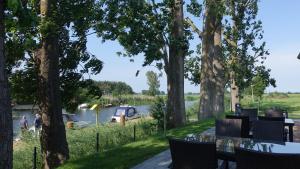 uitzicht op een meer met een tafel en stoelen bij Apartamenty Między Mostami in Stegna