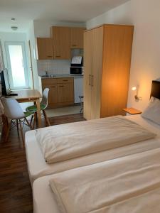um quarto com uma cama grande e uma cozinha em Fleiner Gästehaus em Flein