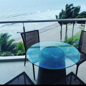 a glass table and chairs on a balcony with the beach at Makana Tonsupa - Suites Familiares 311 y 421 - Deluxe Suites in Tonsupa