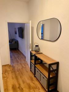 een kamer met een spiegel aan de muur en een tafel bij Exkl. helles Apartment mit Balkon, WLAN& Parkplatz in Maagdenburg