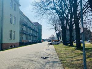 een bakstenen weg met een bank aan de zijkant van een gebouw bij Exkl. helles Apartment mit Balkon, WLAN& Parkplatz in Maagdenburg