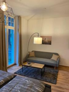 een woonkamer met een bank en een salontafel bij Exkl. helles Apartment mit Balkon, WLAN& Parkplatz in Maagdenburg