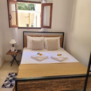 a bedroom with a bed with two towels on it at Apartamentos Terra Mar in Trancoso