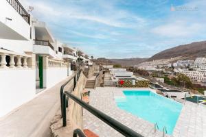 a view from the balcony of a hotel with a swimming pool at Cozy Home in the Heart of Puerto Rico in Puerto Rico de Gran Canaria