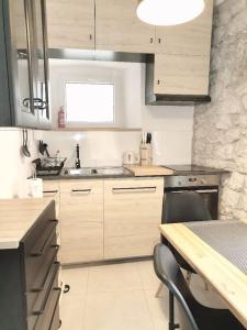 a kitchen with wooden cabinets and a table with a chair at House Marineta - Makarska promenade in Makarska