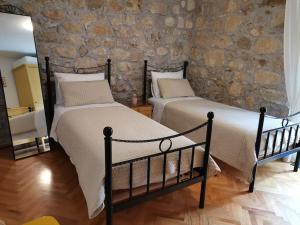 two beds in a bedroom with a stone wall at House Marineta - Makarska promenade in Makarska