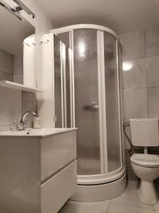 a white bathroom with a shower and a toilet at House Marineta - Makarska promenade in Makarska