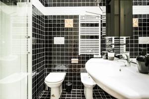 a black tiled bathroom with a toilet and a sink at Merveilleux 2P, à 50 m de la plage, en plein centre ville in Menton