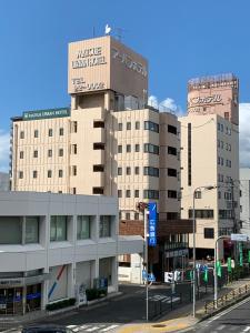 a tall building with a sign on the top of it at Matsue Urban Hotel in Matsue