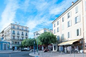 a city street with buildings and a cloudy sky at Merveilleux 2P, à 50 m de la plage, en plein centre ville in Menton