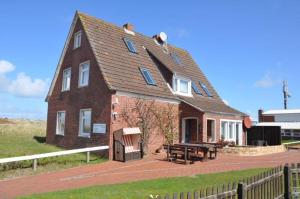a brick house with a picnic table in front of it at Ferienhaus Nordstrand Whg 2 in Baltrum