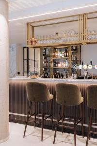 a bar in a restaurant with two chairs and a mirror at The CORNR Hotel in Nieuwpoort