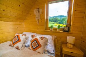 una camera con un letto in una cabina di legno di Dom na Rumiankach 