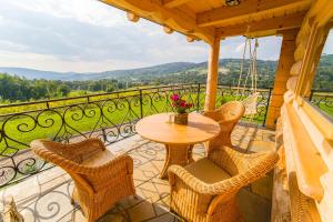 un patio con tavolo e sedie sul balcone. di Dom na Rumiankach 