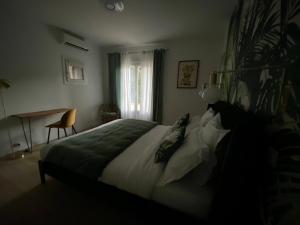1 dormitorio con cama, escritorio y ventana en Chambres d'Hôtes La Bastide St Julien en Anduze