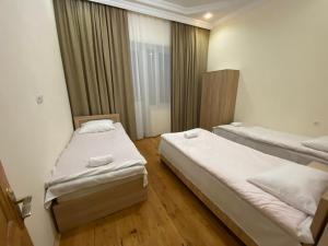 een slaapkamer met 2 bedden en een raam bij Guesthouse LUKA in Koetaisi