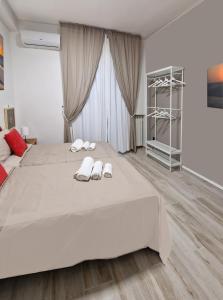 - une chambre avec un grand lit et des chaussons dans l'établissement SAINT GEORGE'S HOUSE 3 Bari, à Bari