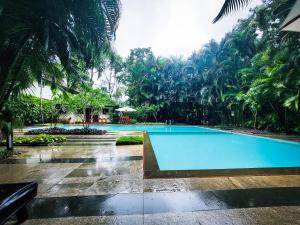 a swimming pool in the middle of a resort at Greenwoods Resort, Thekkady in Thekkady