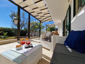 un patio con una mesa con 2 copas de vino en Villa Maria, en Santa Cesarea Terme