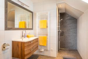 ein Badezimmer mit einem Waschbecken und einer Dusche mit gelben Handtüchern in der Unterkunft Moamoosgut in Göriach