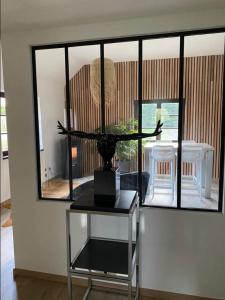 a room with a table with a vase on it at Le logis des Chênes, superbe bungalow dans quartier résidentiel proche de Namur in Wépion