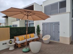 a patio with a bench and an umbrella at Meco Beach Villa in Sesimbra