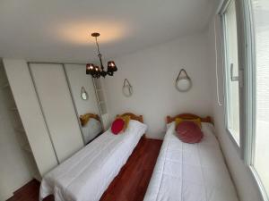 2 camas en una habitación pequeña con ventana en Playa 2 en Mar del Plata