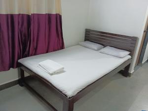 a bed with two pillows on it in a room at Mhatre Cottage Alibag Mani in Alibaug