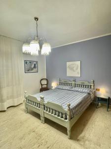 - une chambre avec un lit et un lustre dans l'établissement Casa Di Zule, à Quartu SantʼElena