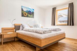 ein Schlafzimmer mit einem Bett und einem hölzernen Nachttisch in der Unterkunft Moamoosgut in Göriach