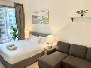 ein Schlafzimmer mit einem Bett und einem Sofa in der Unterkunft Super Elegant studio apartment-Sparkle tower By SWEET HOMES in Dubai