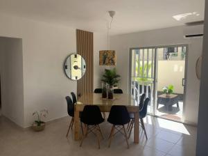 uma sala de jantar com mesa e cadeiras e um relógio em Iris Vacation Lovely Place em La Romana