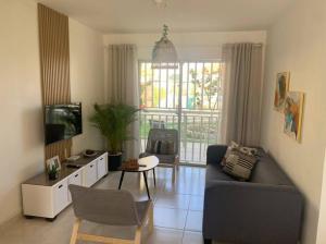 a living room with a couch and a tv at Iris Vacation Lovely Place in La Romana