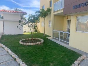 a building with a small tree in the middle of a yard at Iris Vacation Lovely Place in La Romana