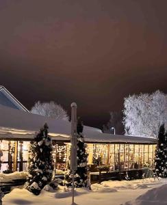 uma casa coberta de neve à noite com luzes em Vanha Ravintola Ölvin Suolatorilla - Vanhan Kanttorilan yhteydessä em Lovisa
