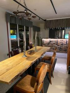 einen großen Holztisch und Stühle in einem Zimmer in der Unterkunft Vanha Ravintola Ölvin Suolatorilla - Vanhan Kanttorilan yhteydessä in Lovisa
