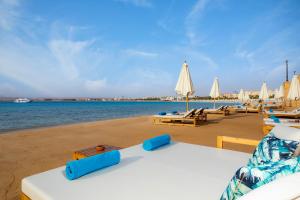 a beach with chairs and umbrellas and the water at Zen Resort Sahl Hasheesh by TBH Hotels in Hurghada