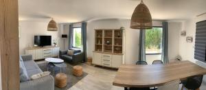 ein Wohnzimmer mit einem Sofa und einem Tisch in der Unterkunft La Maison Des Sables Blancs in Loctudy