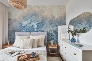 sypialnia z łóżkiem z niebieską ścianą w obiekcie ŻOLI STORK APARTMENTS - Hubnera 1 w Warszawie