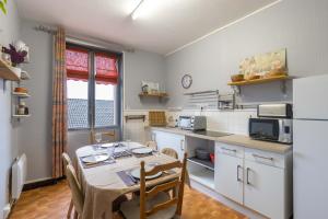 a kitchen with a table and chairs and a refrigerator at CABANA & Confort - Proche Centre-Ville , Parking in Tournus