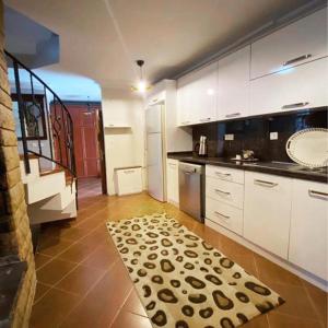 a kitchen with white cabinets and a rug on the floor at ÇEKMEKÖY VİLLA in Reşadiye
