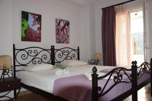 a bedroom with a black bed and a window at Rastoni Apartments in Andros
