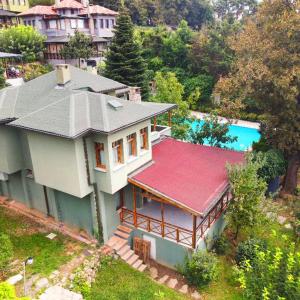 uma casa com um telhado vermelho e uma piscina em ÇEKMEKÖY VİLLA em Reşadiye