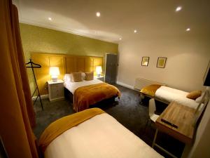 ブラックプールにあるCaptivating 4-Bed Hot Tub House in Blackpoolのベッド2台とデスクが備わるホテルルームです。