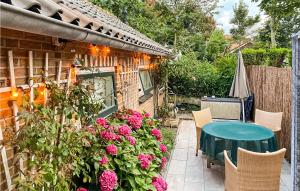 a patio with a green table and flowers at 1 Bedroom Gorgeous Home In Zoutelande in Zoutelande