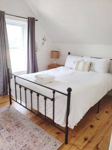 a bedroom with a large bed with white sheets at Wild Rose in Picton