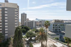 vistas a una ciudad con palmeras y edificios en Apartamentos Michel Angelo Benidorm en Benidorm