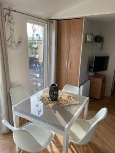 un tavolo bianco con sedie bianche e un vaso sopra di Chalet Lieblingsplatz a Lauwersoog Altre 13 foto